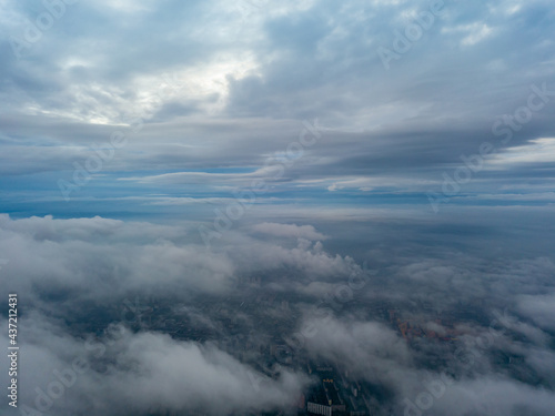 City under the clouds at dawn. Aerial high drone view.