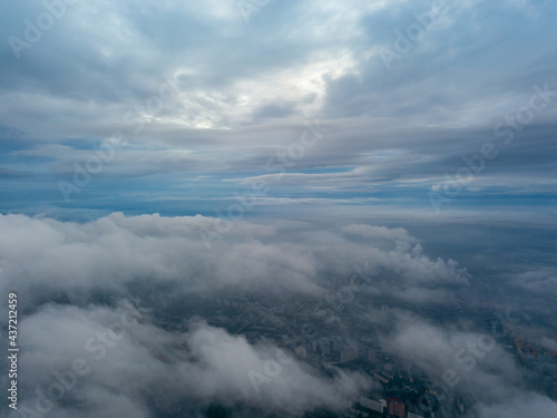 City under the clouds at dawn. Aerial high drone view. © Sergey