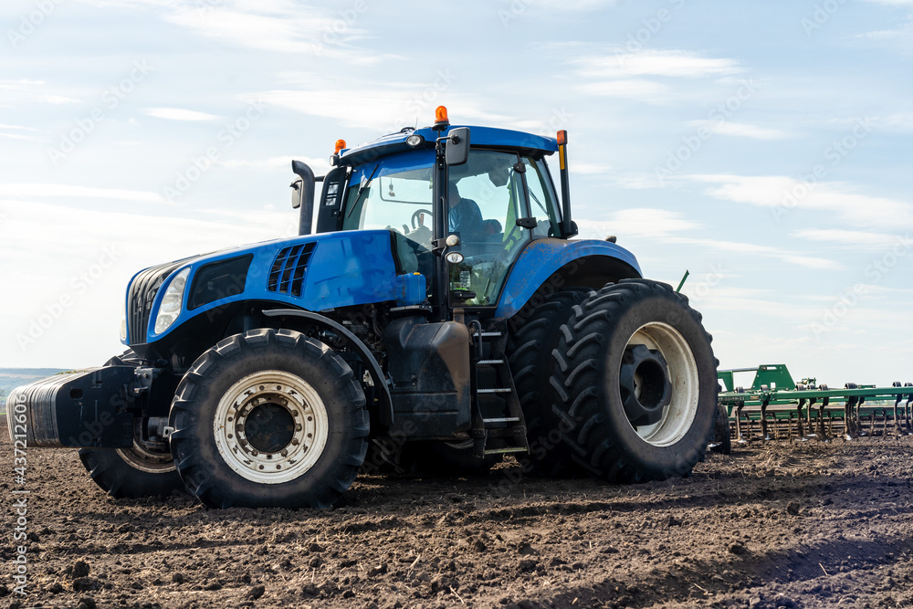 A tractor with seedbed cultivator ploughs field on morning. A tractor with seedbed cultivator ploughs field on morning.