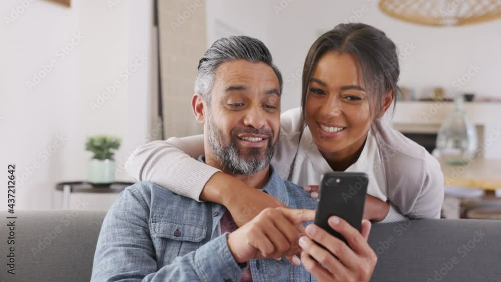 Happy indian couple using smartphone at home Happy indian couple using smartphone at home
