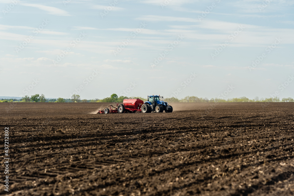 A tractor cultivating field at spring morning. A tractor cultivating field at spring morning.