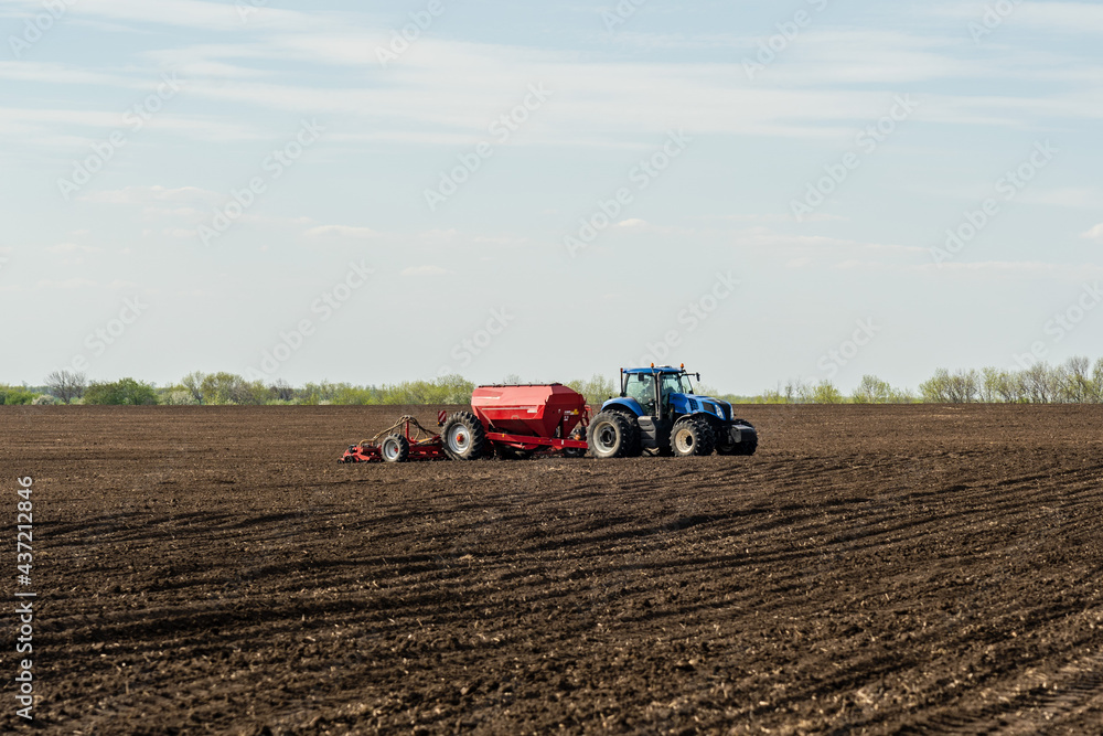 A tractor cultivating field at spring morning. A tractor cultivating field at spring morning.