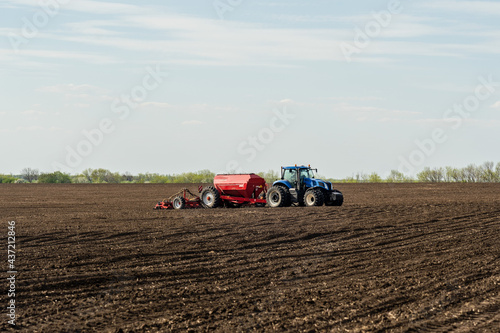 A tractor cultivating field at spring morning.