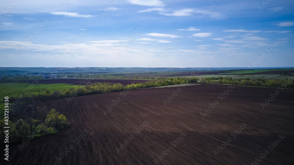 Aerial view of plowing fields under the blue sky