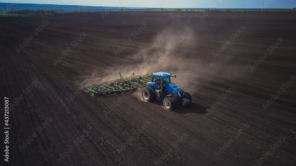 Aerial image of a tractor with seedbed cultivator ploughs field