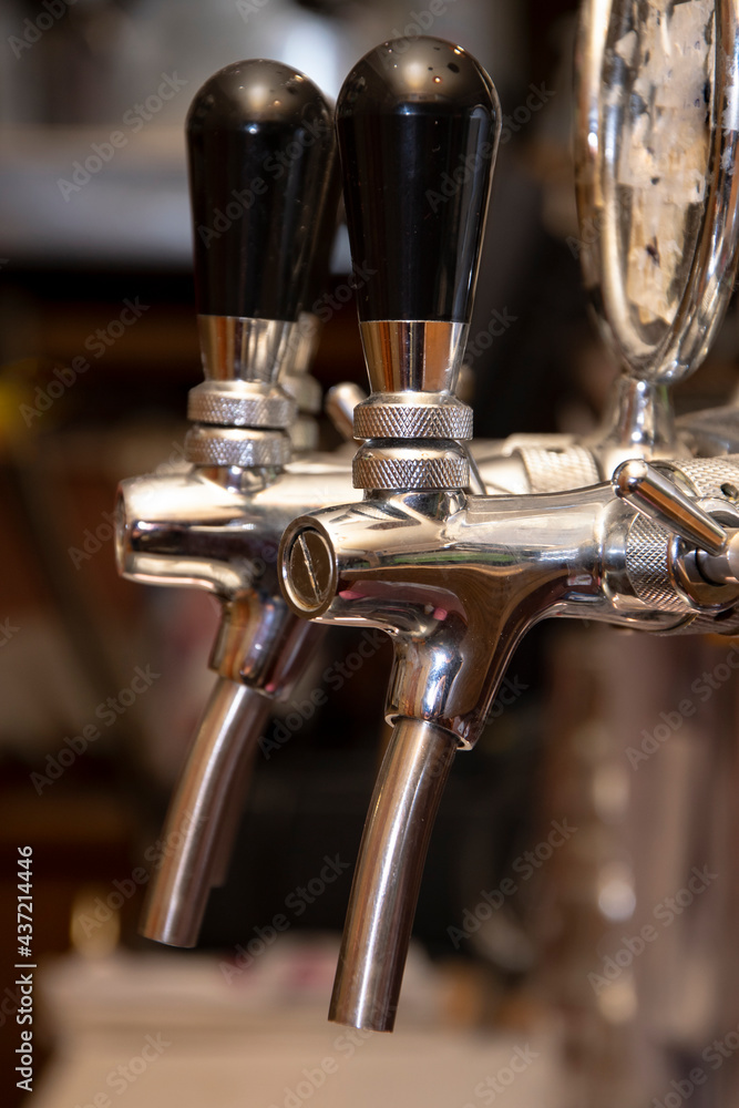 Hand-held tap pump for beer filling in the bar behind the bar, close-up, selective focus.
