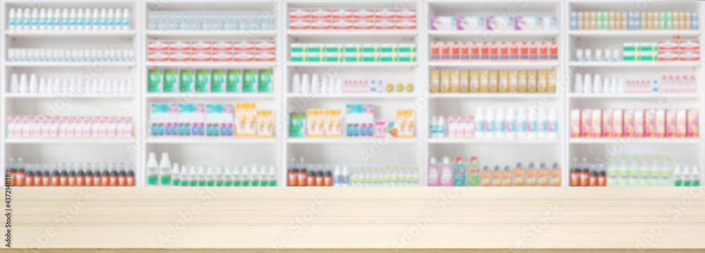 Empty wood counter top with pharmacy drugstore shelves blur pharmaceutical background
