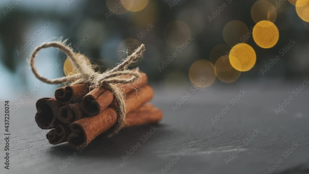 Dried cinnamon rolled in sticks and tied with rope on dark background Dried cinnamon rolled in sticks and tied with rope on dark background