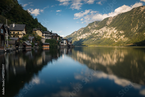 Reflections of village houses and mountain landscapes in a crystal clear lake in the town of Hallstatt in Austria. 