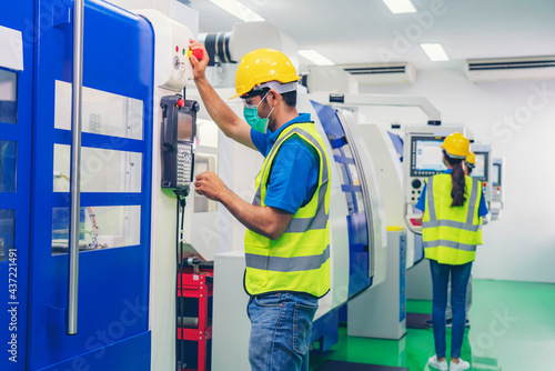 Male industrial engineer or technician worker using control machine operating control CNC machinery at factory Industrial.