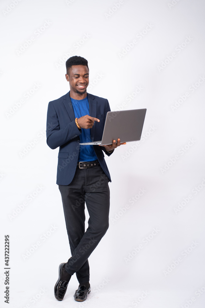 young black businessman holding a laptop and smiling while pointing to it, advertising concept young black businessman holding a laptop and smiling while pointing to it, advertising concept