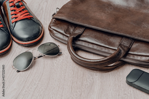 Top view of men set shoes, glasses, bag on wooden background