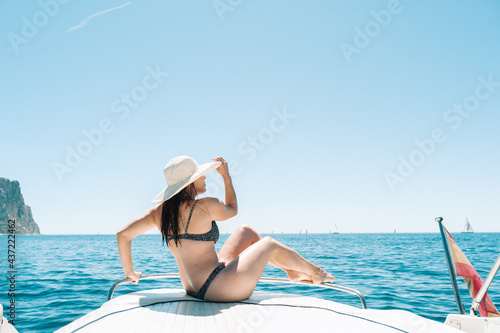 Brunette woman sitting on boat deck at the mediterranean sea