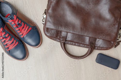 Top view of men set shoes, bag on wooden background
