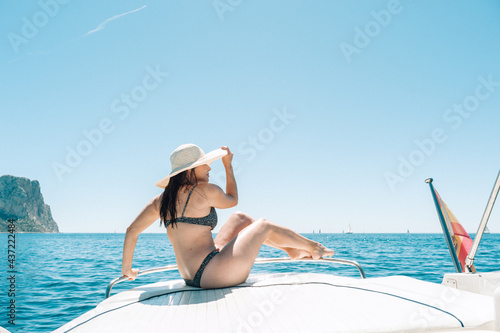 Brunette woman sitting on boat deck at the mediterranean sea