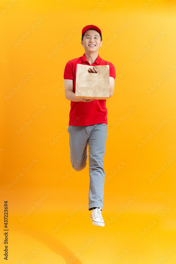 Delivery employee man hold brown craft paper bag for takeaway and jumping Delivery employee man hold brown craft paper bag for takeaway and jumping