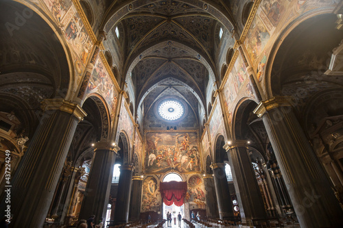 Cremona, Italy - June 2, 2021: symmetrical interior view of Santa Maria Assunta cathedral, people are visible in the distance. 