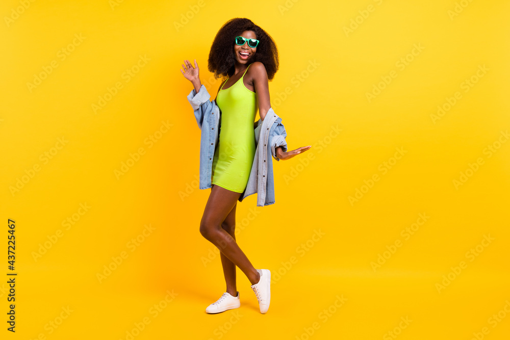 Full length body size photo of girl in stylish outfit sunglass relaxing on weekend dancing isolated vibrant yellow color background Full length body size photo of girl in stylish outfit sunglass relaxing on weekend dancing isolated vibrant yellow color background