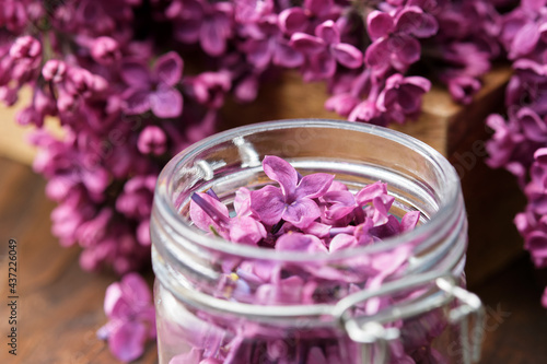 Lilac flowers in a jar  bunch of Syringa flowers. The preparation of infusion  aromatic sugar or jam from Lilac flowers at home.