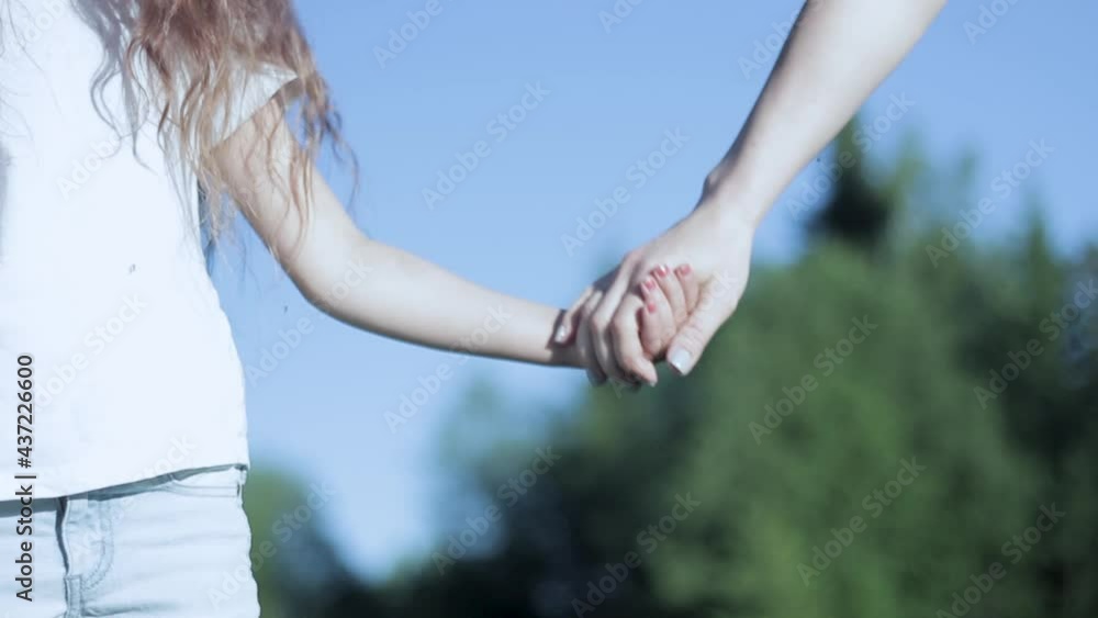 Сloseup hands of mom and daughter hold together in nature Сloseup hands of mom and daughter hold together in nature