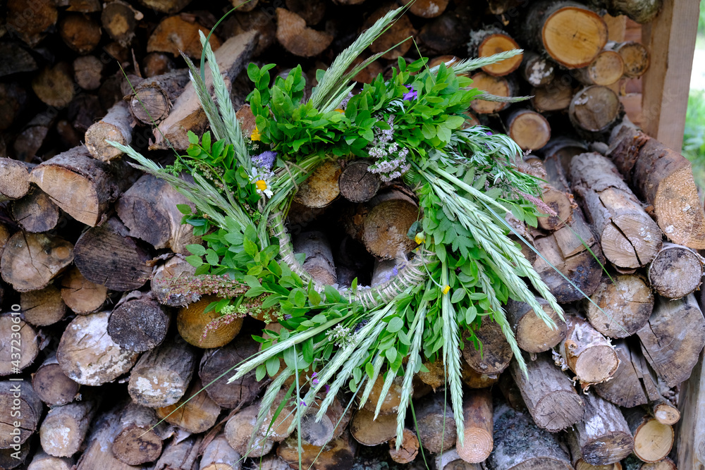 A wreath of flowers, bent and greenery hung at a ridge of firewood during the summer solstice festival A wreath of flowers, bent and greenery hung at a ridge of firewood during the summer solstice festival