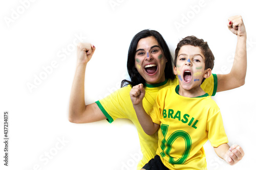 Amazing scene of Brazilian fans celebrating over white background. Family cheering together. Woman and little boy smiling.