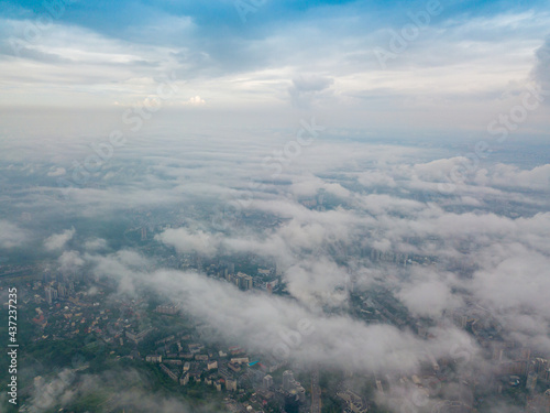 High flight above the clouds in Kiev. Spring morning. Aerial high view.