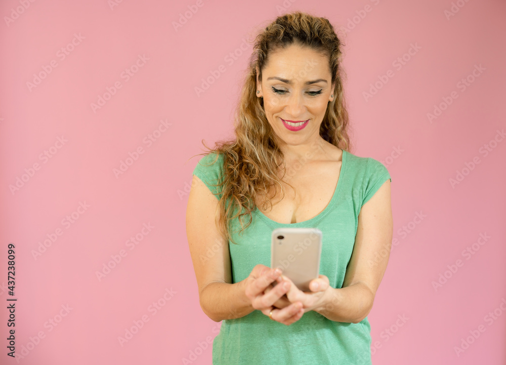 Smiling woman talking on mobile phone isolated over pink background. Smiling woman talking on mobile phone isolated over pink background.