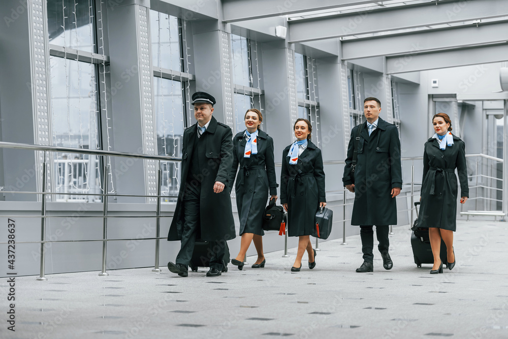 Obraz premium Aircraft crew in work uniform is together outdoors in the airport