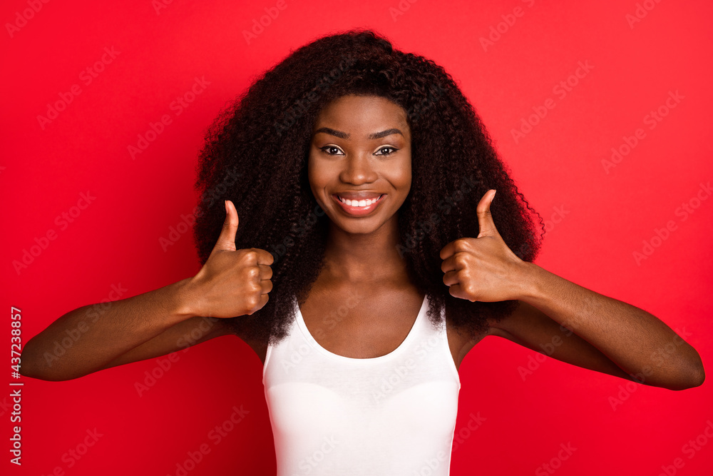 Photo of young african girl happy positive smile show thumb-up like cool fine isolated over red color background Photo of young african girl happy positive smile show thumb-up like cool fine isolated over red color background