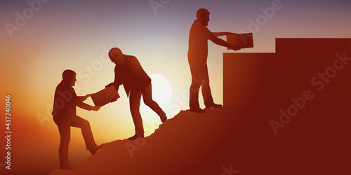 Symbole du travail d’équipe en entreprise avec un groupe qui s’entraide pour atteindre son objectif en bâtissant un mur au sommet d’une montagne.