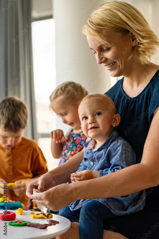 Kids playing with plasticine. Teacher or mother play with children. People, kid creativity concept Kids playing with plasticine. Teacher or mother play with children. People, kid creativity concept