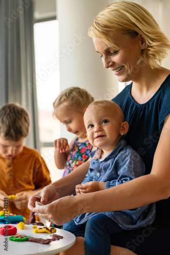 Kids playing with plasticine. Teacher or mother play with children. People, kid creativity concept