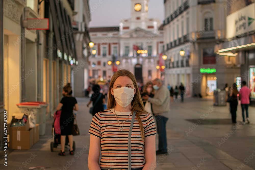 Prevention of coronavirus outbreak in 2020. Portrait of young European woman wearing a mask in the city street. Medical mask. FFP2 mask Prevent pollution and disease concept.