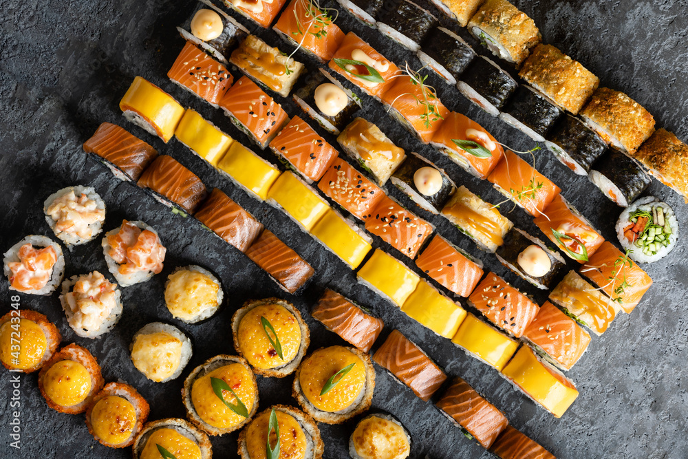 Japanese sushi food collection. Maki ands rolls with tuna, salmon, shrimp, crab and avocado. Top view of assorted sushi. Rainbow sushi roll, uramaki, hosomaki and nigiri.