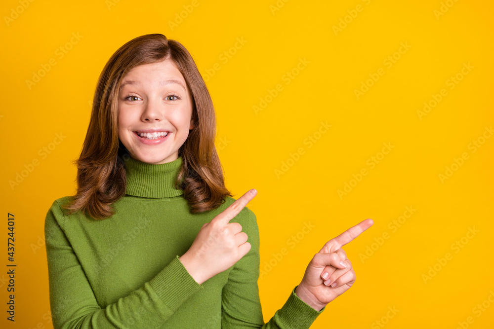 Photo portrait girl cheerful showing finger copyspace isolated vibrant yellow color background Photo portrait girl cheerful showing finger copyspace isolated vibrant yellow color background
