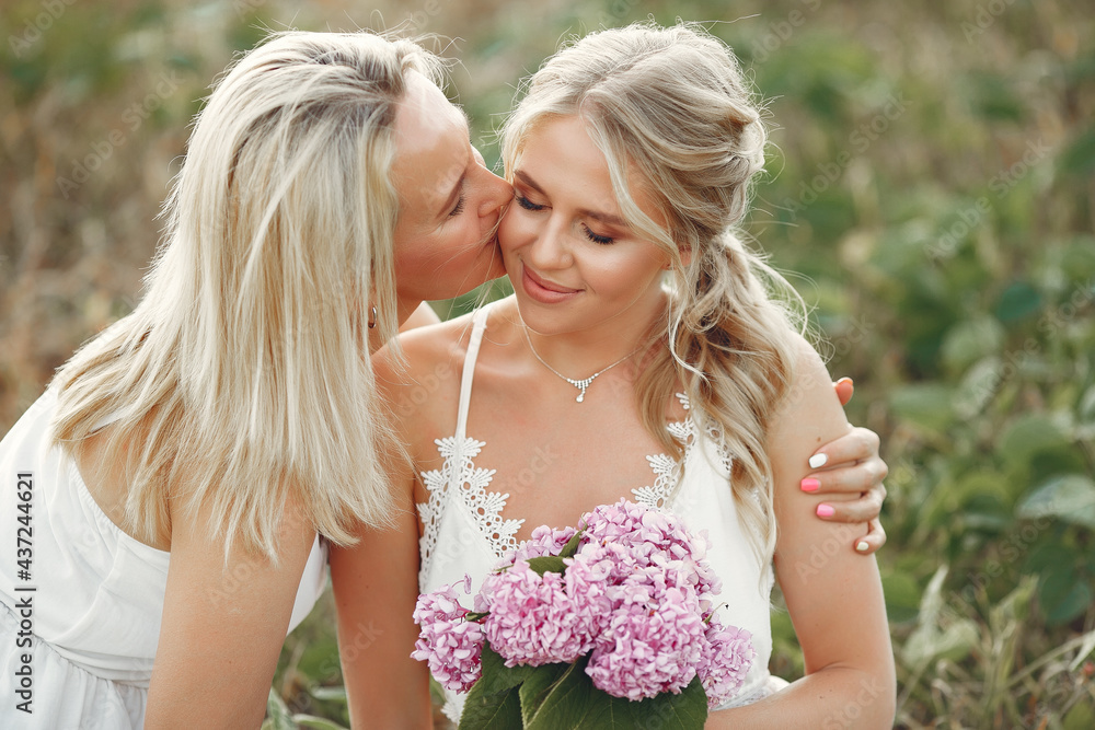 Mother with beautiful daughter in a autumn field
