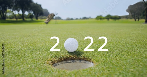 Composition of 2022 number with golf ball by hole on golf course