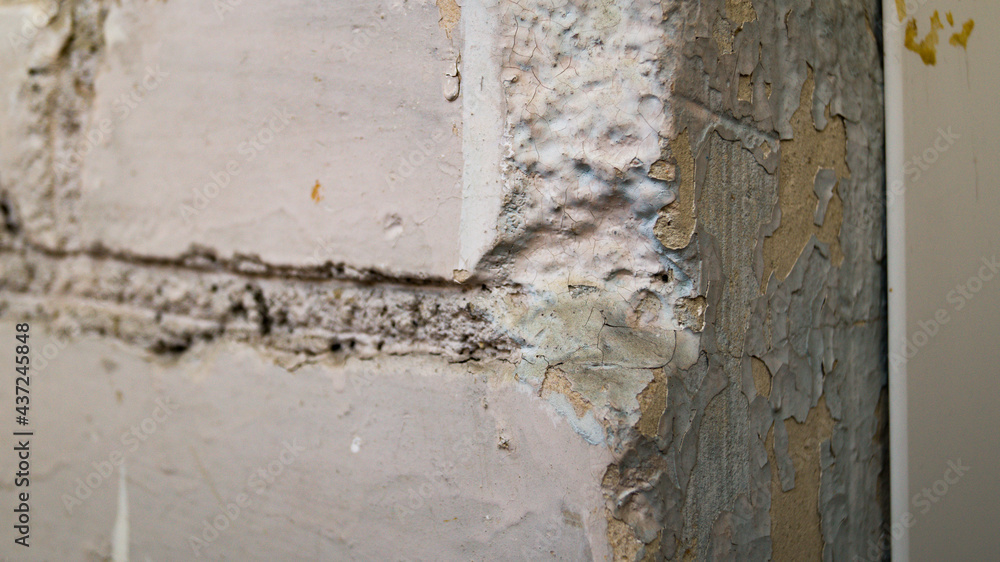 A peeled side of plaster against an old brick wall. The old finish is falling off the wall. The concept of repair, construction, decoration. A peeled side of plaster against an old brick wall. The old finish is falling off the wall. The concept of repair, construction, decoration.