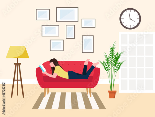 A woman is reading a book on the sofa in the living room. Interior Design. Flower in a pot, paintings in a frame and a screen.