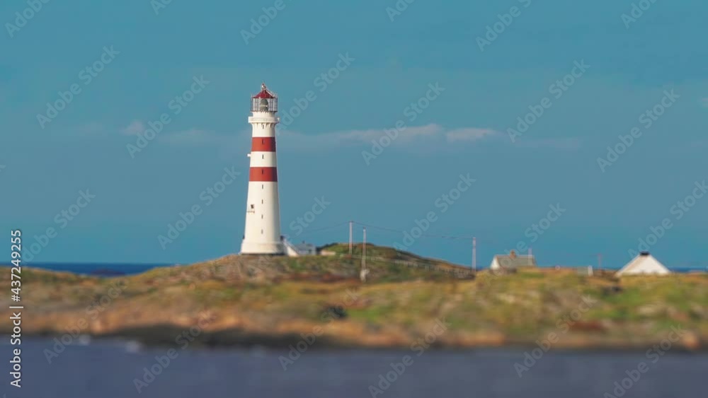 Kristiansand lighthouse Oksøy or fyr Oksoy standing on the island in the sea greeting sailors and travelers. Small houses also stand on the island - home to the lighthouse keeper. Kristiansand lighthouse Oksøy or fyr Oksoy standing on the island in the sea greeting sailors and travelers. Small houses also stand on the island - home to the lighthouse keeper.