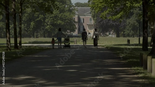 Wallpaper Mural Family walking over path in green park with a beautiful mansion in the background Torontodigital.ca