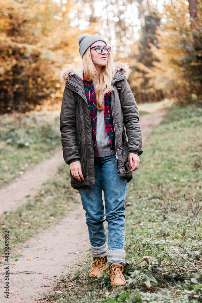 Hiking and travel along in the forest. Concept of trekking, adventure and seasonal vacation. Young woman walking in woods. Hiking and travel along in the forest. Concept of trekking, adventure and seasonal vacation. Young woman walking in woods.