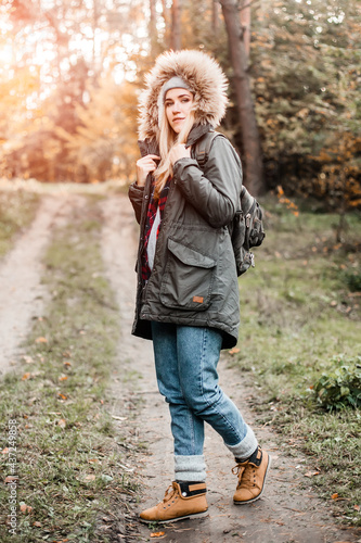 Hiking and travel along in the forest. Concept of trekking, adventure and seasonal vacation. Young woman walking in woods.