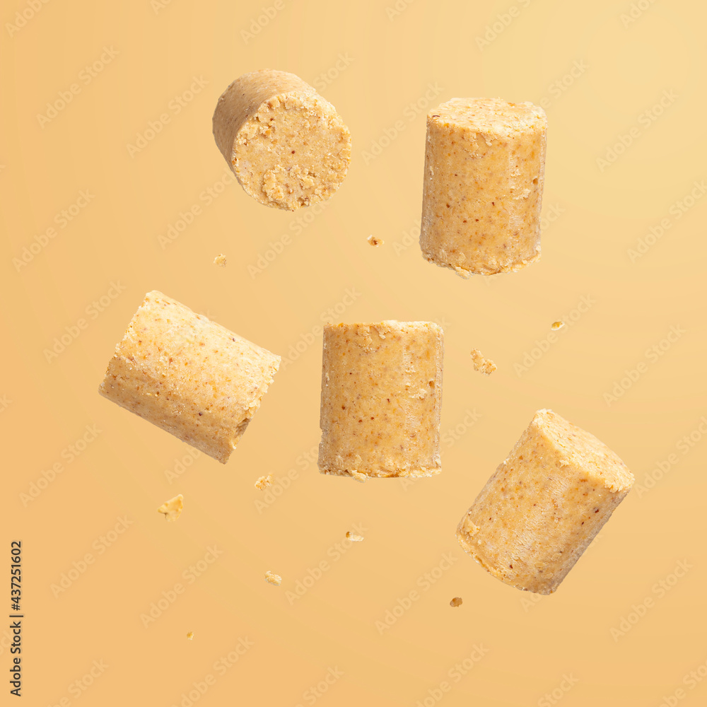 Sweet Brazilian peanut called Paçoca falling down on orange background. From June Celebration Sweet Brazilian peanut called Paçoca falling down on orange background. From June Celebration