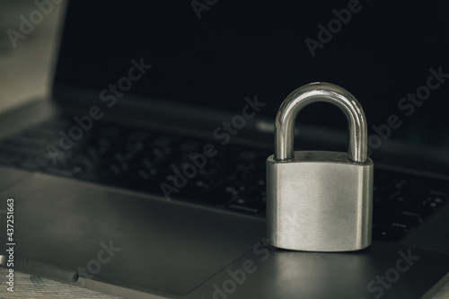 computer security concept, safety stainless steel padlock on the laptop computer(dark tone)