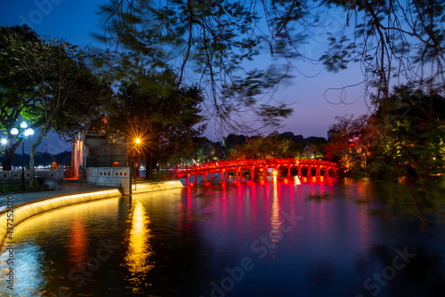 Hanoi Red Bridge at night. The wooden red-painted bridge over the Hoan Kiem Lake connects the shore and the Jade Island on which Ngoc Son Temple stands photo