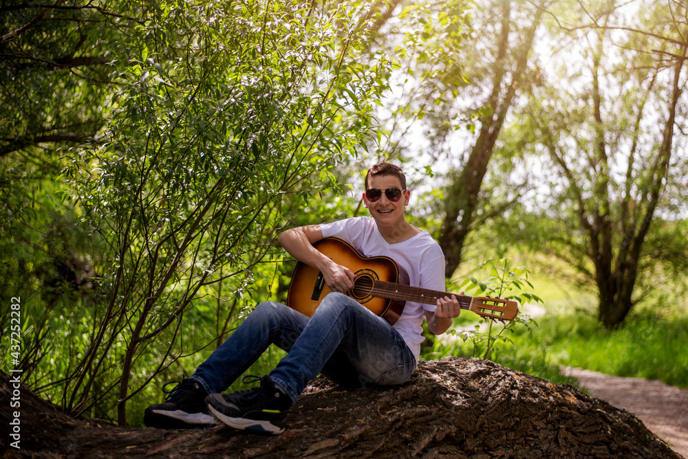 Portrait of beautiful teenager playing guitar outside