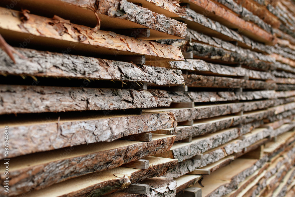 Unedged board of soft wood stacked in the open air. Selective focus. Unedged board of soft wood stacked in the open air. Selective focus.