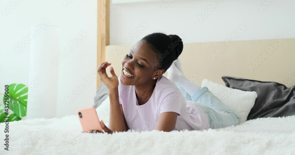 Cheerful woman taking selfie using mobile phone lying in bed at home Cheerful woman taking selfie using mobile phone lying in bed at home
